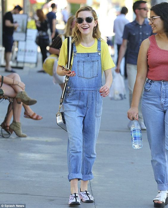 Kiernan Brennan com t-shirt amarela e jardineira jeans