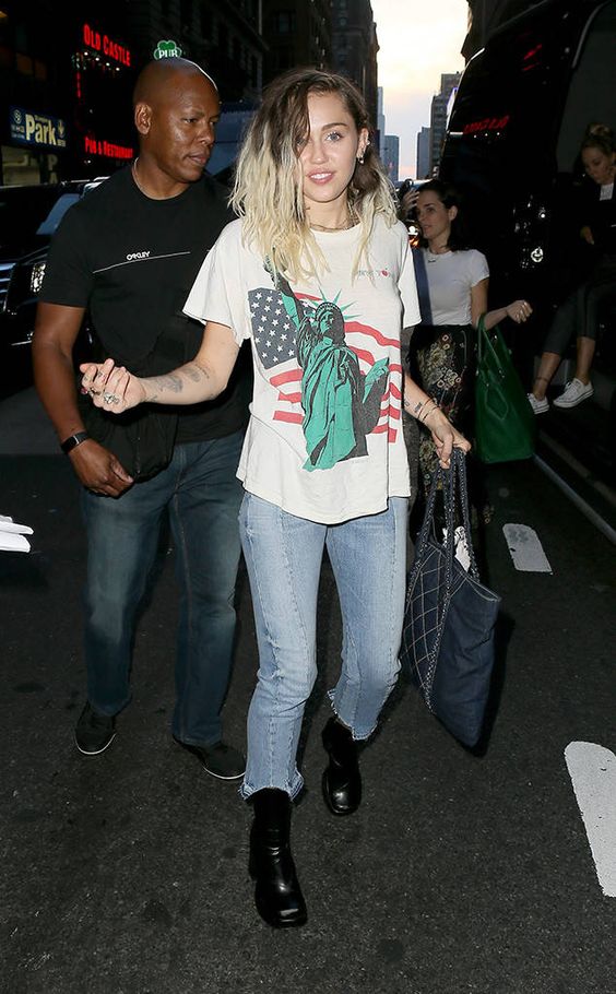 Miley Cyrus, t-shirt estampada e calça jeans desfiada