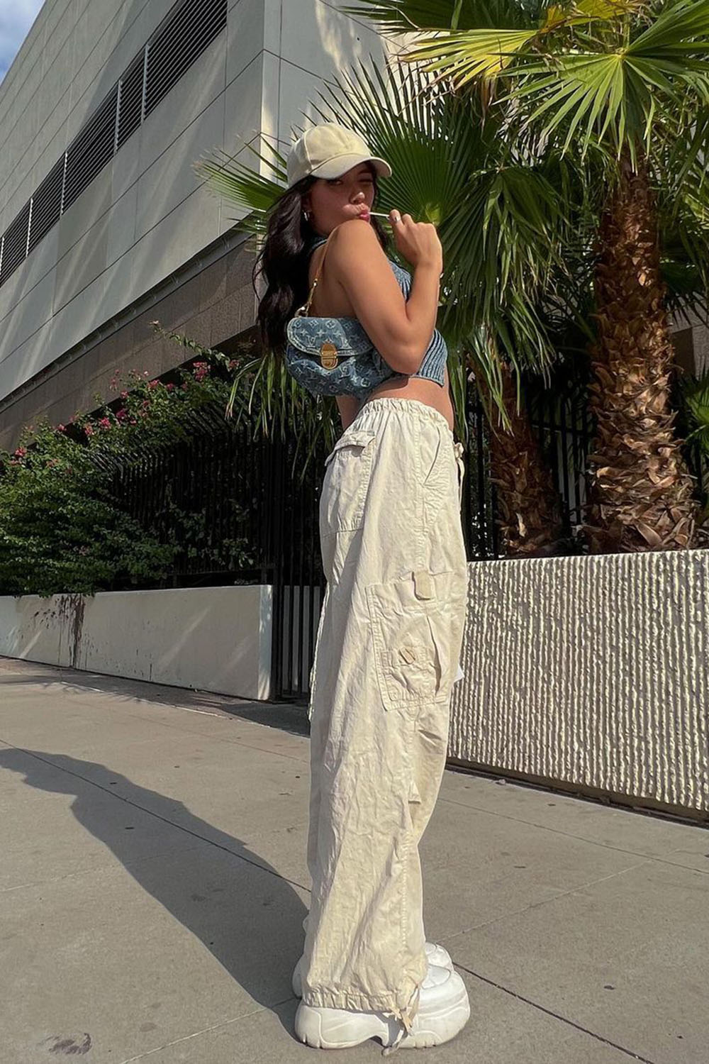 calça corta vento, boné, bolsa baguete e cropped