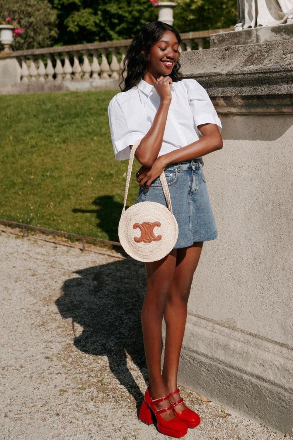 camisa branca, minissaia jeans, bolsa redonda Chanel e sapato de boneca vermelha