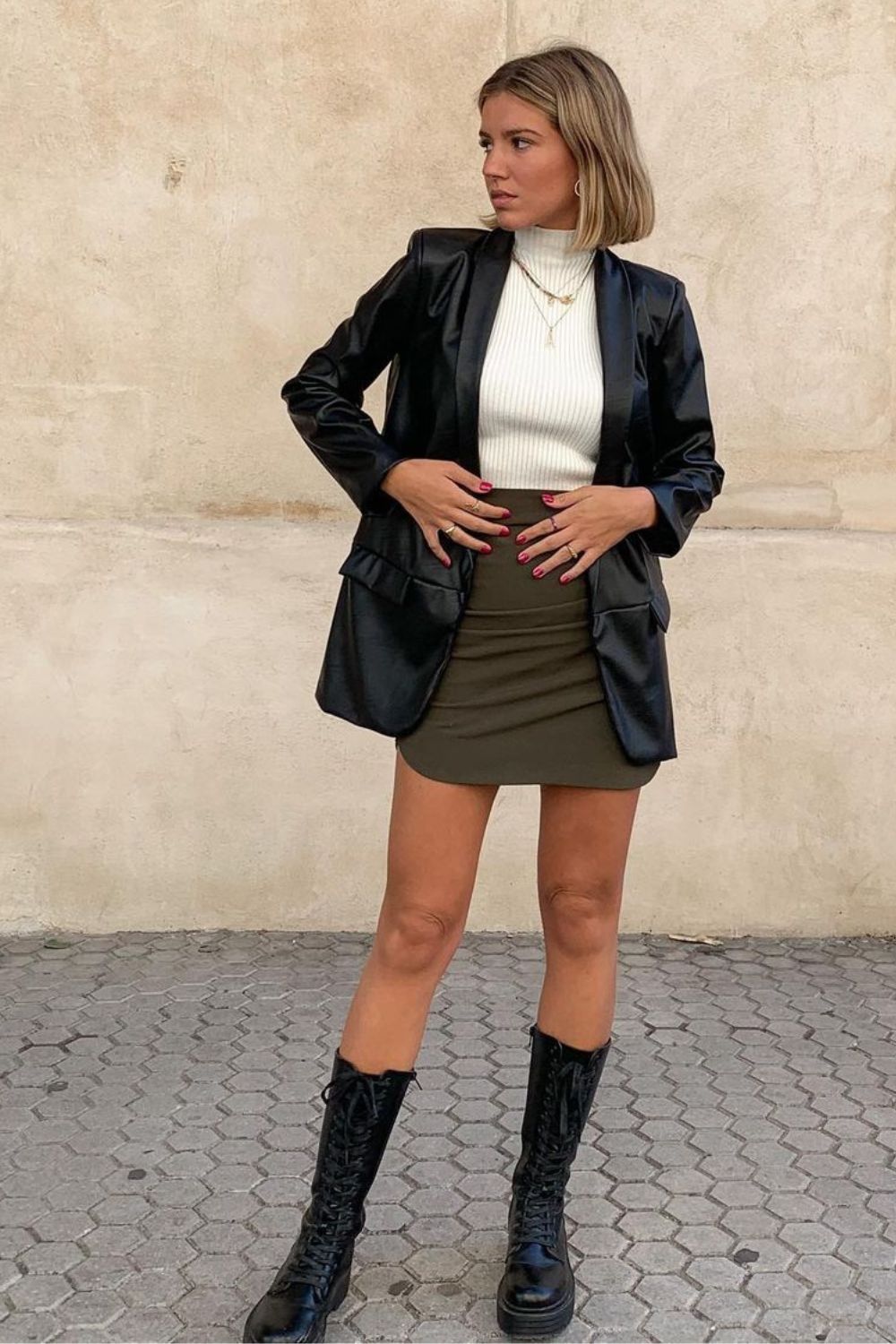 Blusa de gola alta, blazer preto de vinil, minissaia e coturno