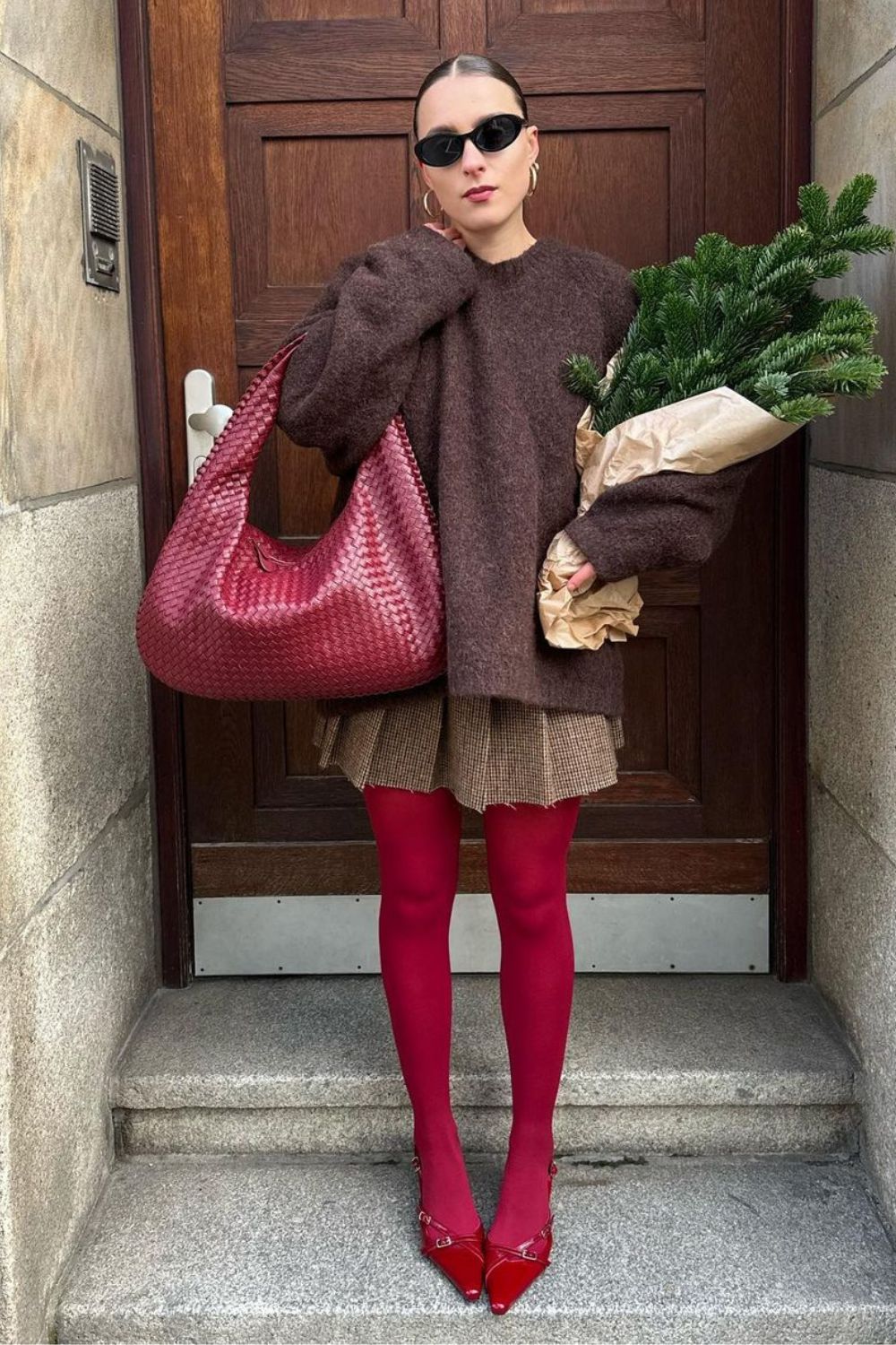 Suéter oversized marrom, sia plissada, bolsa e meia-calça vermelha com slingback