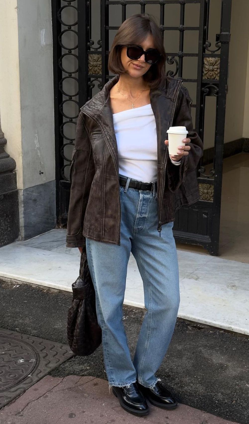Jaqueta de couro marrom, calça jeans reta com loafer finílico