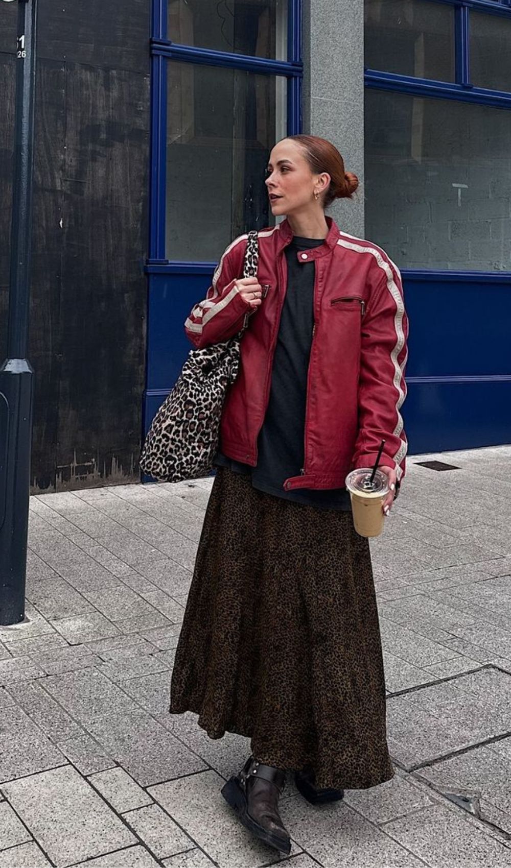 Combinação moderninha de outono com jaqueta de couro vermelha, saia evasê com bota e bolsa com estampa de animal print