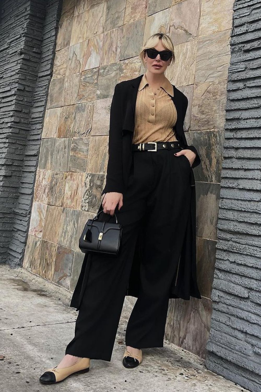 Looks elegantes para trabalhar, blusa gola polo bege com sobretudo preto, calça de alfaiataria wide leg com sapato bicolor.