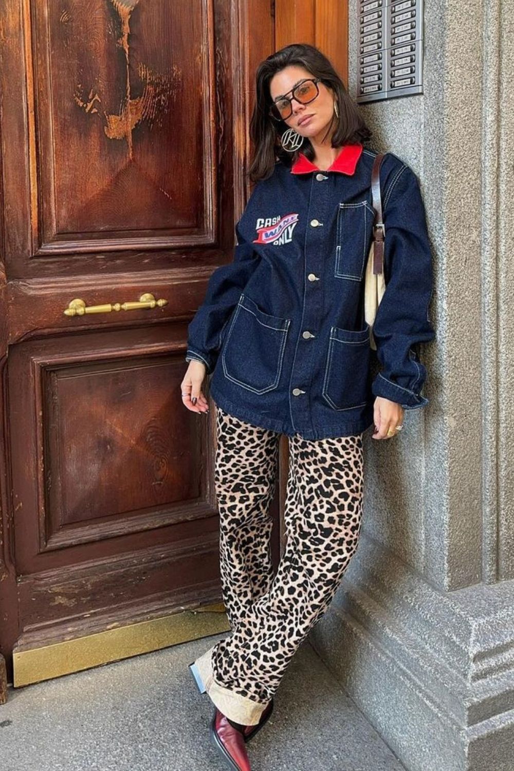 Jaqueta jeans oversized, calça com estampa de leopardo e sapato de bico fino vermelho