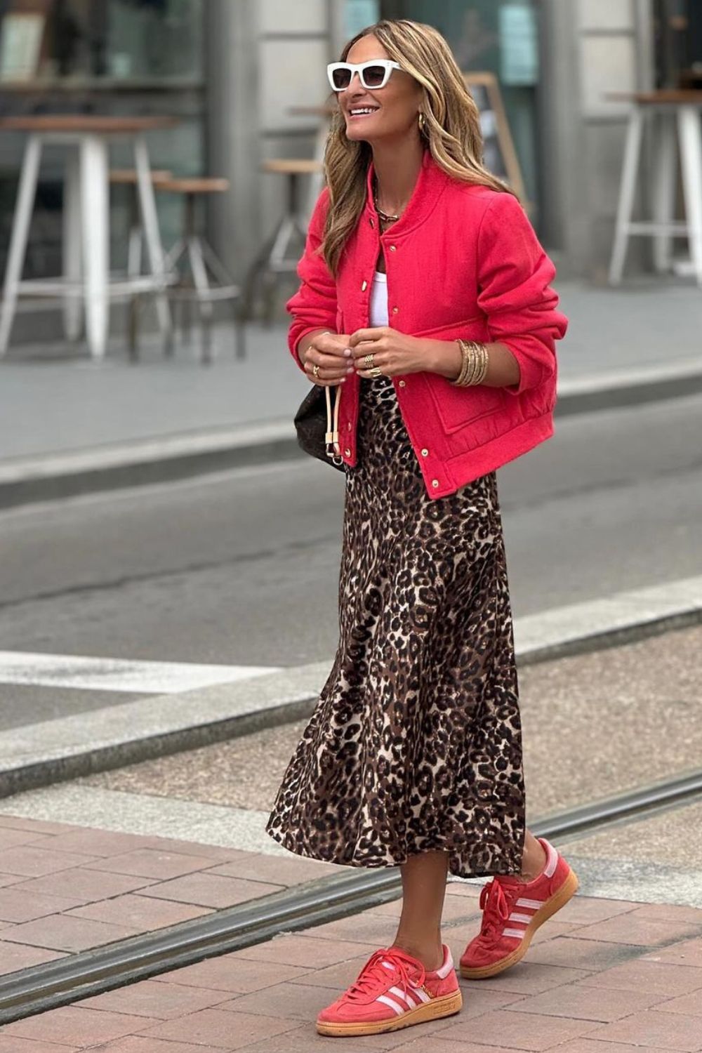 Jaqueta vermelha, saia midi rodada com estampa de animal print e tênis adidas vermelho