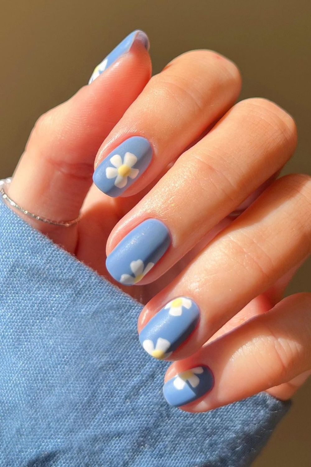 Nail art azul com decoração de flores