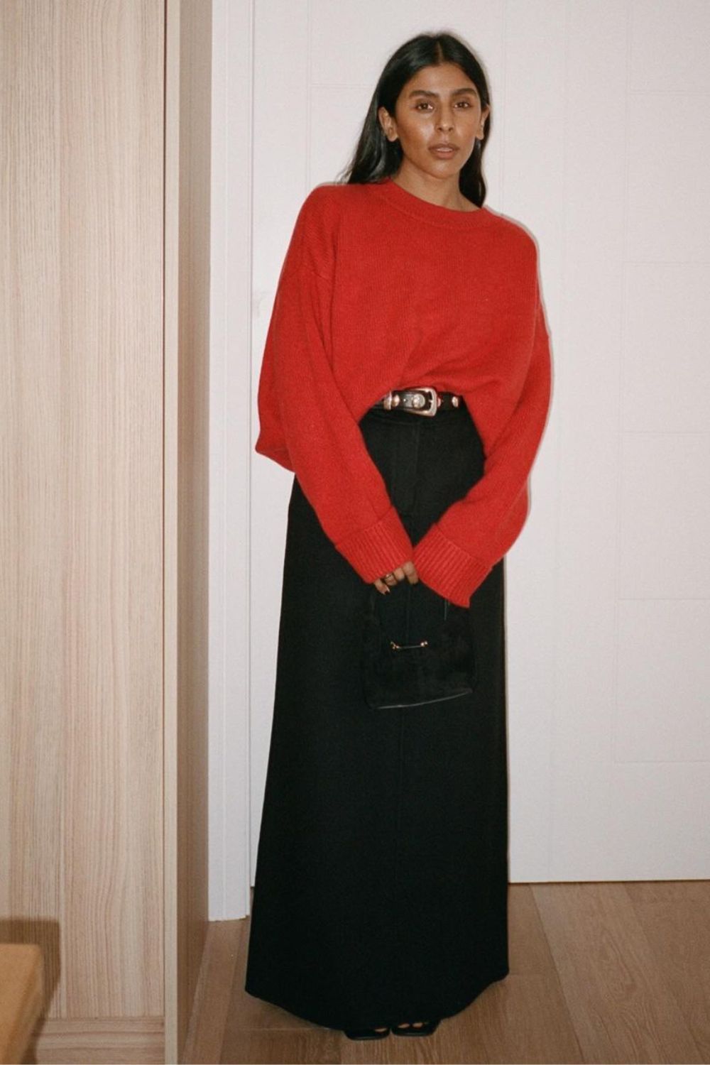 looks elegantes com cardigan vermelho, saia longa preta e cinto preto