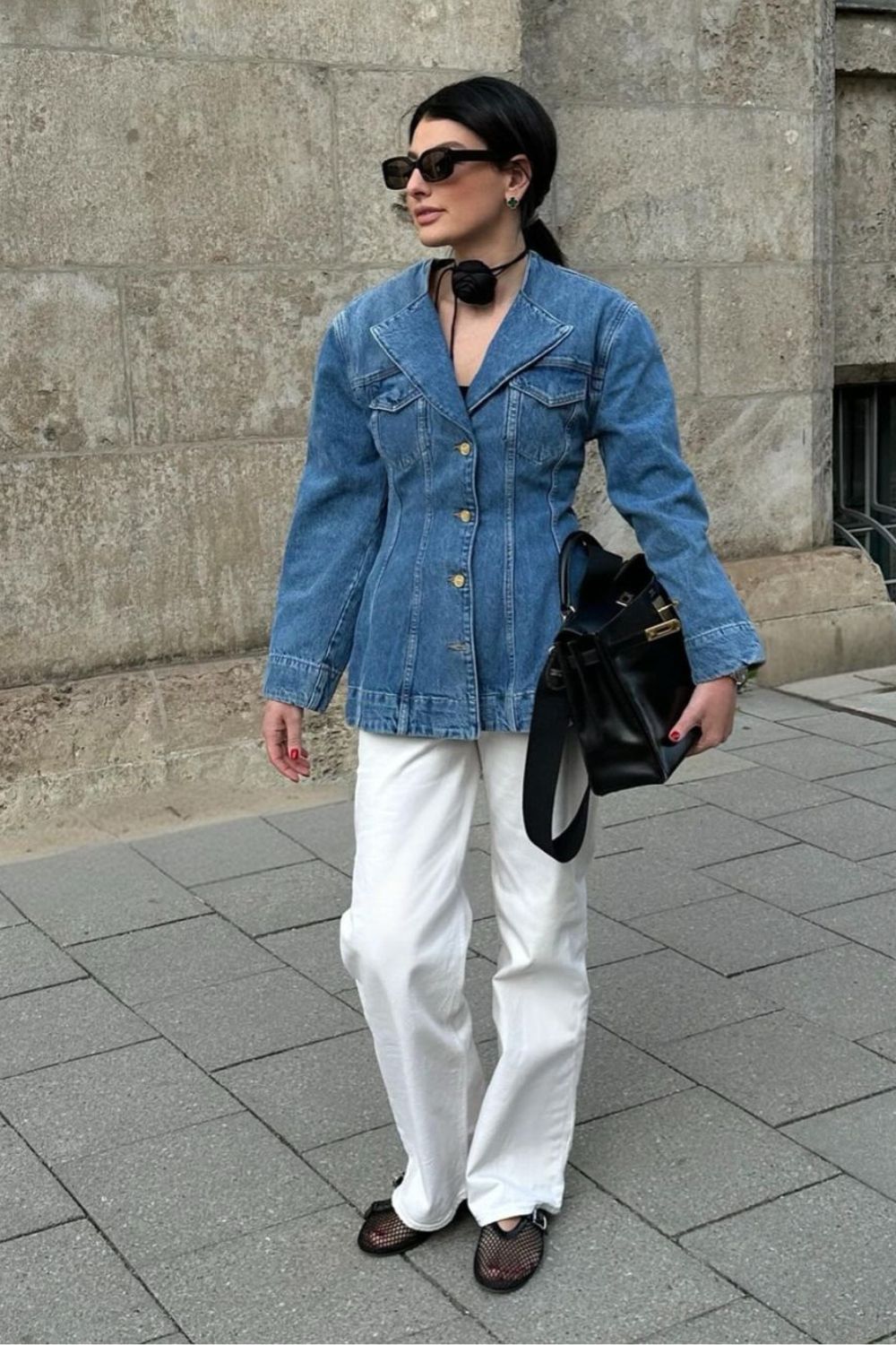 Jaqueta jeans acinturada e calça de alfaiataria branca com sapatilha arrastão