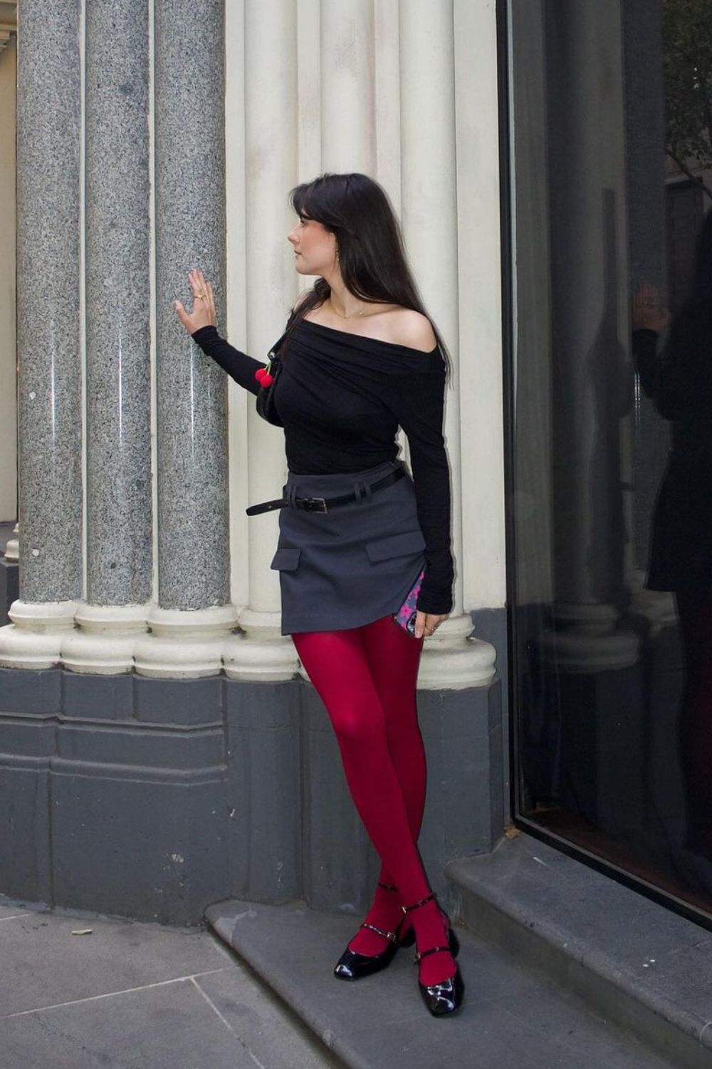 tendências de inverno: blusa ombro a ombro preta, saia de alfaiataria e meia-calça cereja