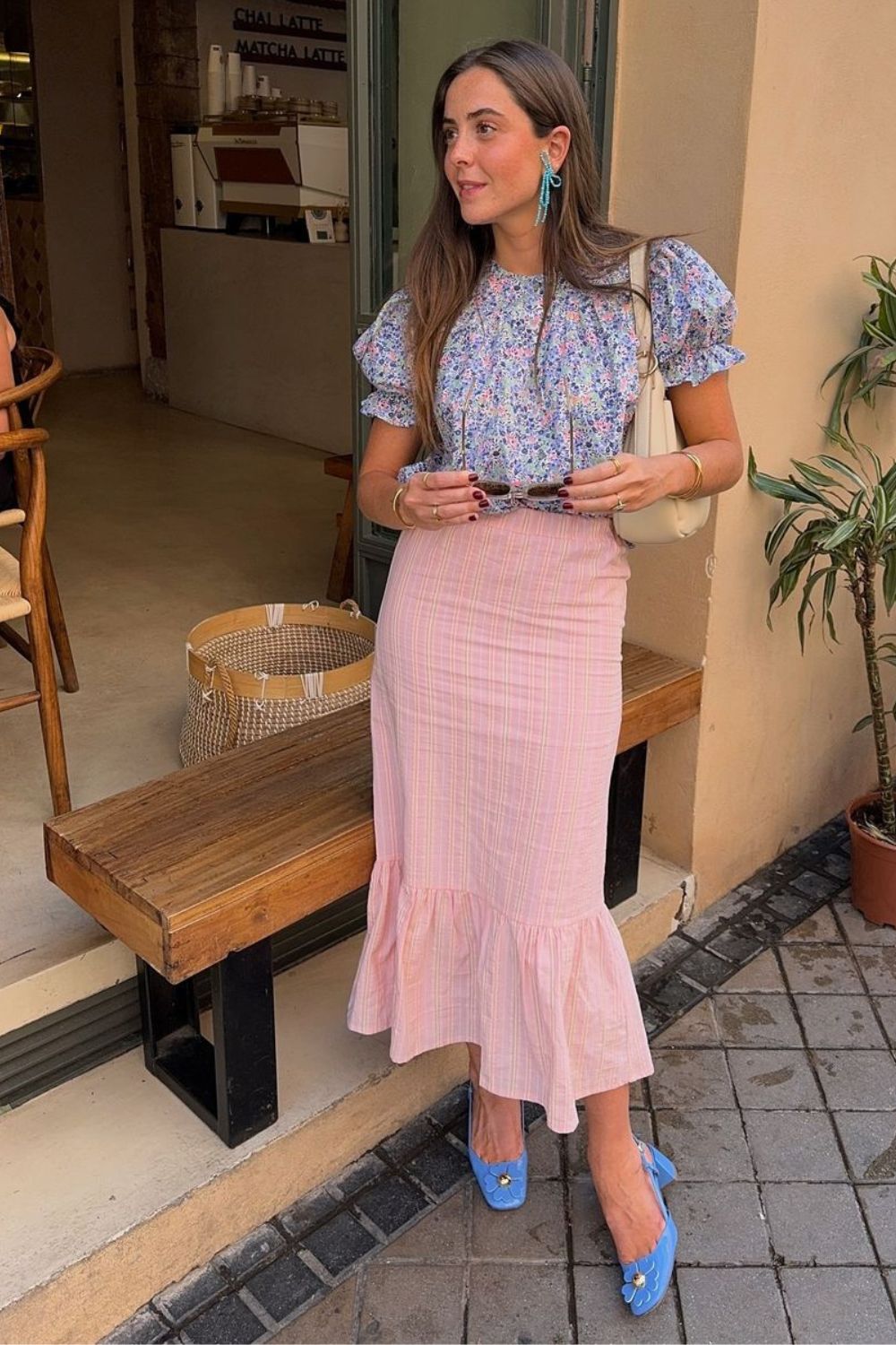 Blusa azul com estampa floral e mangas bufantes, saia midi listrada com babados e slingback azul