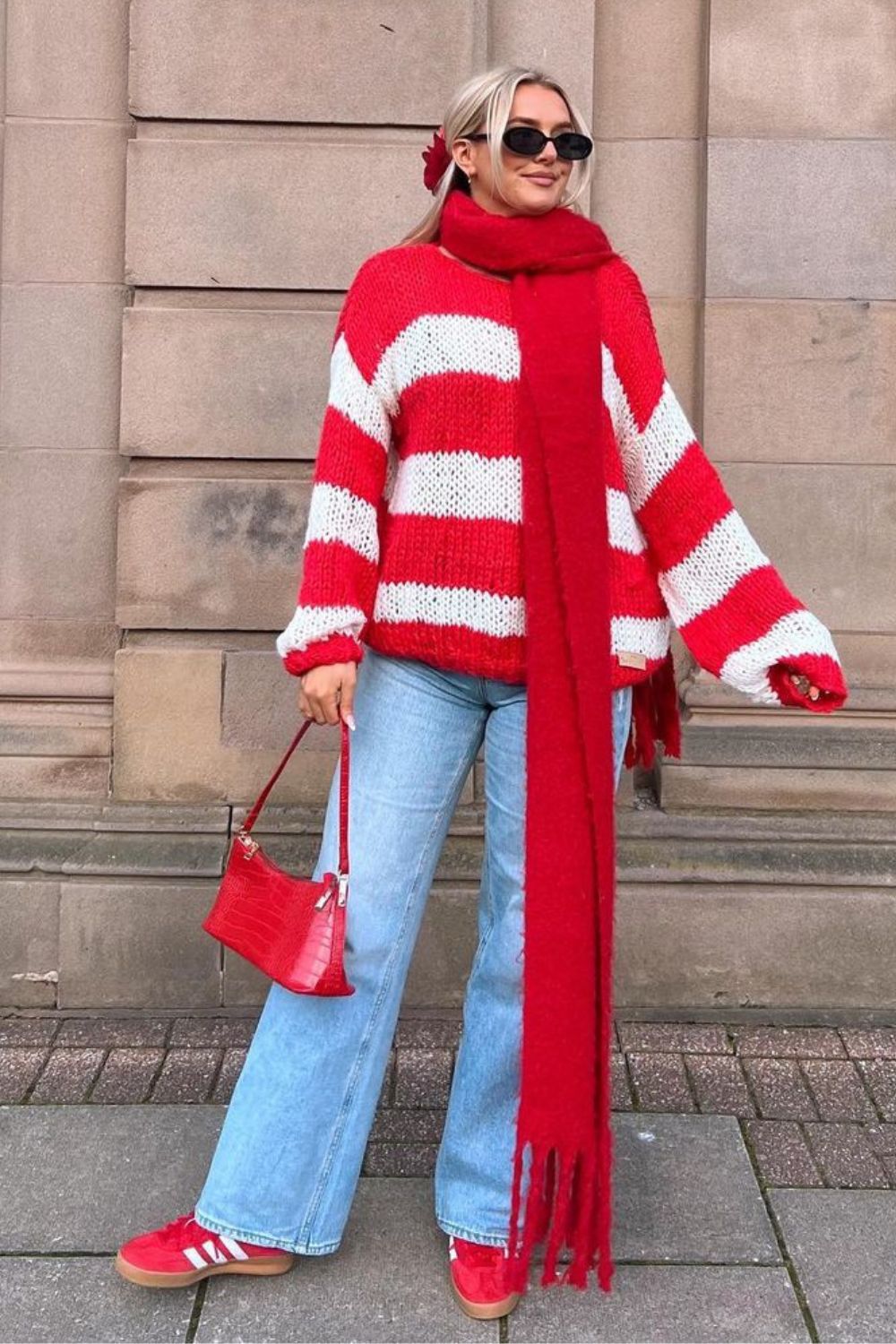 Suéter listrado vermelho e branco, calça jeans reta, cachecol e bolsa vermelha