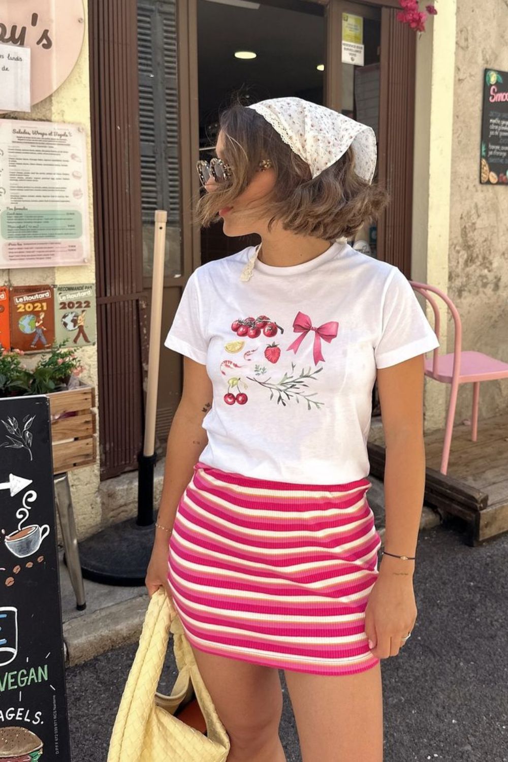 Lenço no cabelo, blusa com estampa fofa e minissaia listrada