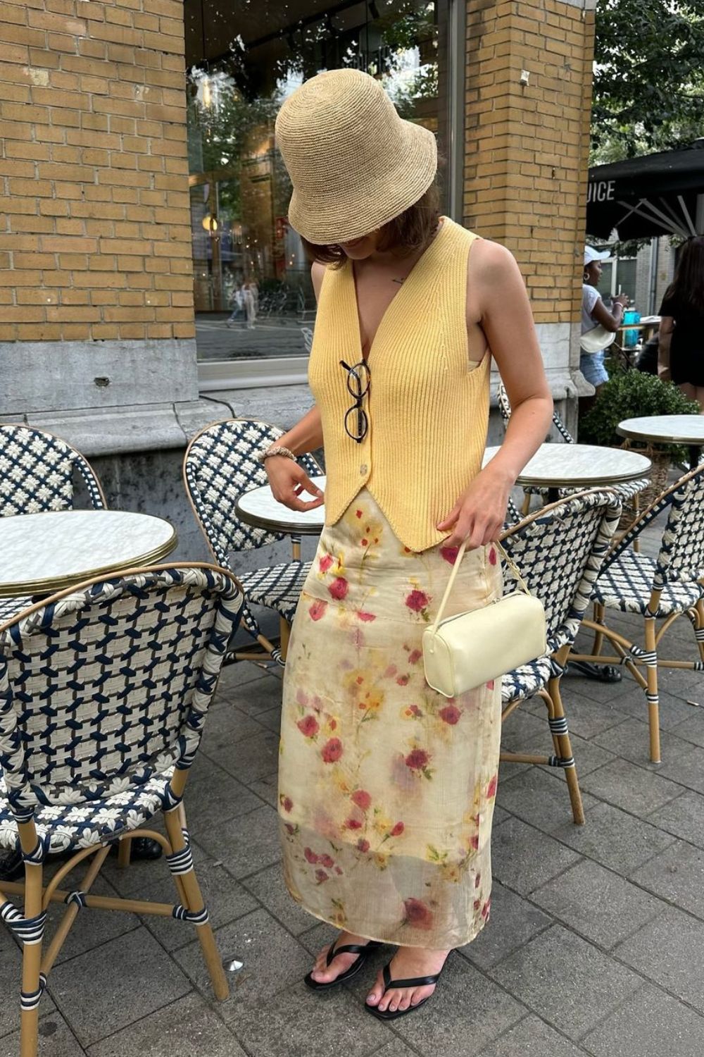 Bucket hat, colete de tricô, saia longa estampada mini bolsa e rasteirinha