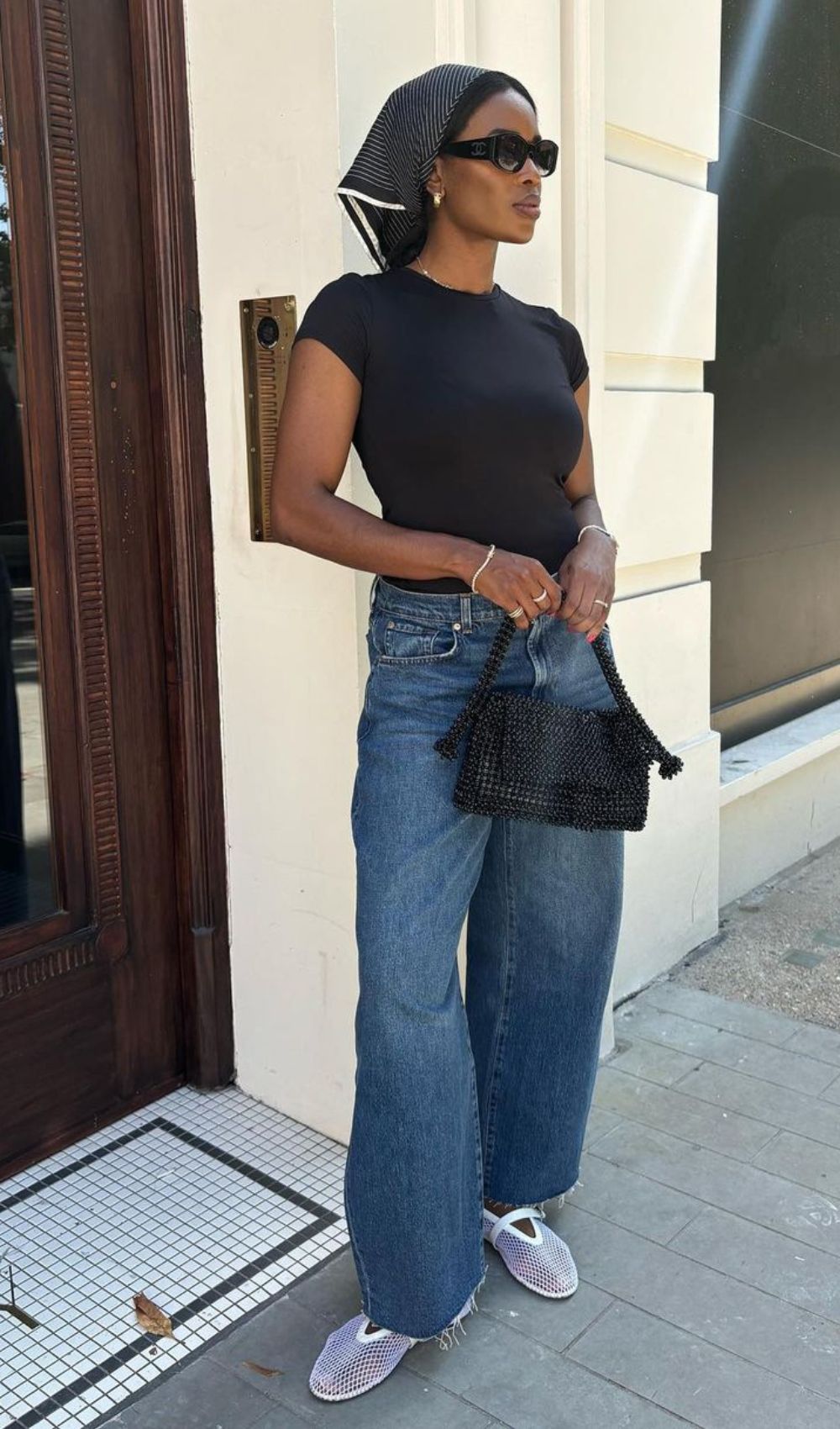 Blusa preta, brandana na cabeça, calça jeans baggy e sapatilha mary Jane vazada