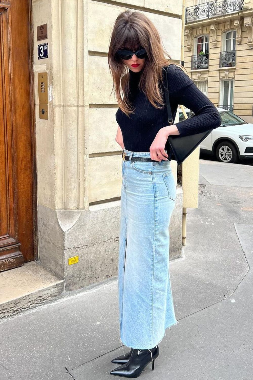 Blusa de manga preta, long skirt jeans, cinto preto e bota de bico fino