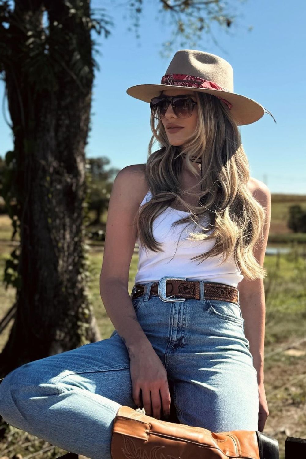 cowgirl aesthetic, chapéu com lenço, regata branca, calça jeans e bota wetern