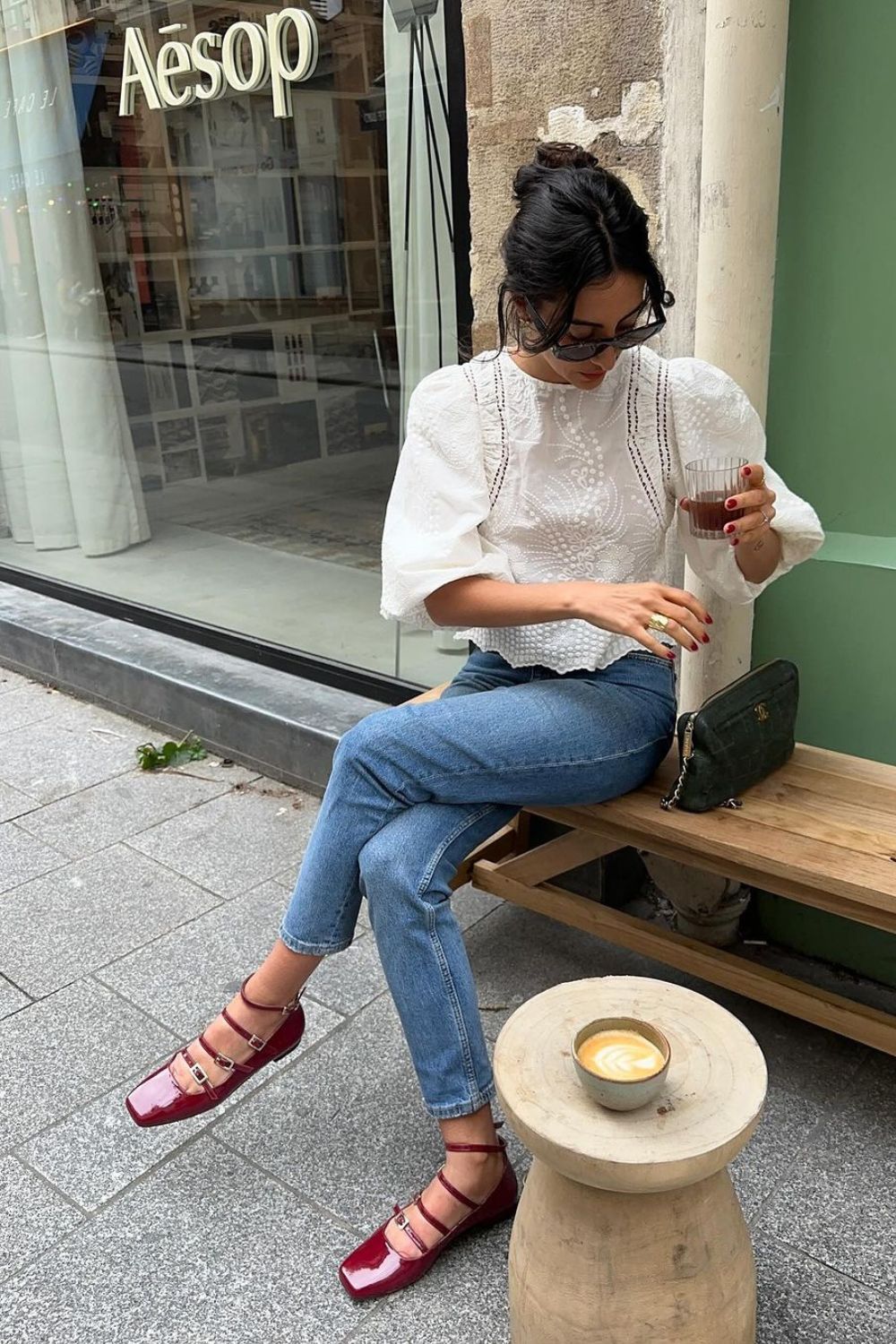 Look de escritório com bata de renda, calça jeans e sapato mary jane vermelho