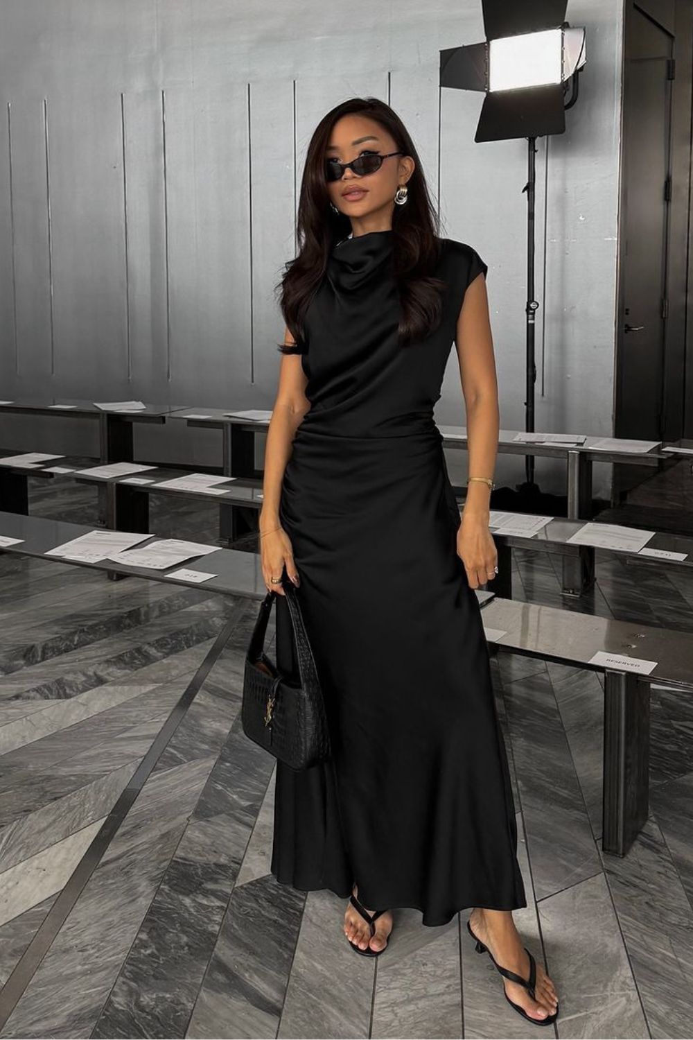 Look all black com vestido midi de seda drapeado e tamanco de tiras