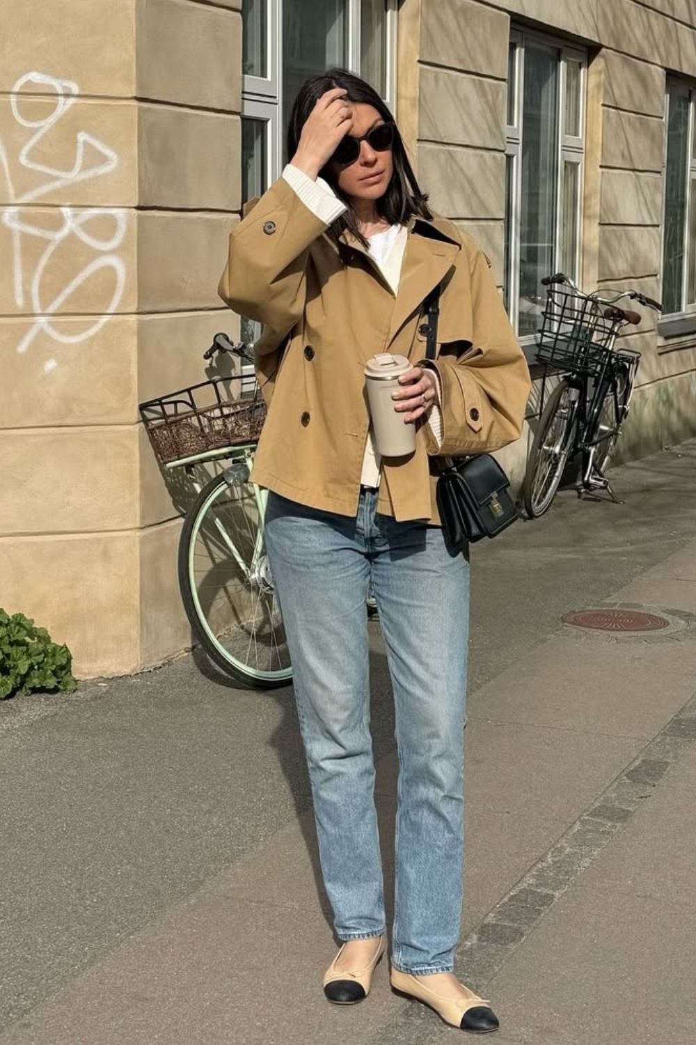 Parka bege, blusa branca, calça jeans e sapatilha bicolor