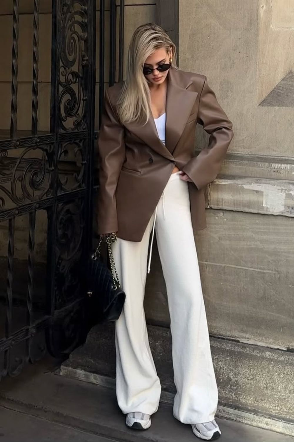 Blazer de couro marrom, calça branca e tênis
