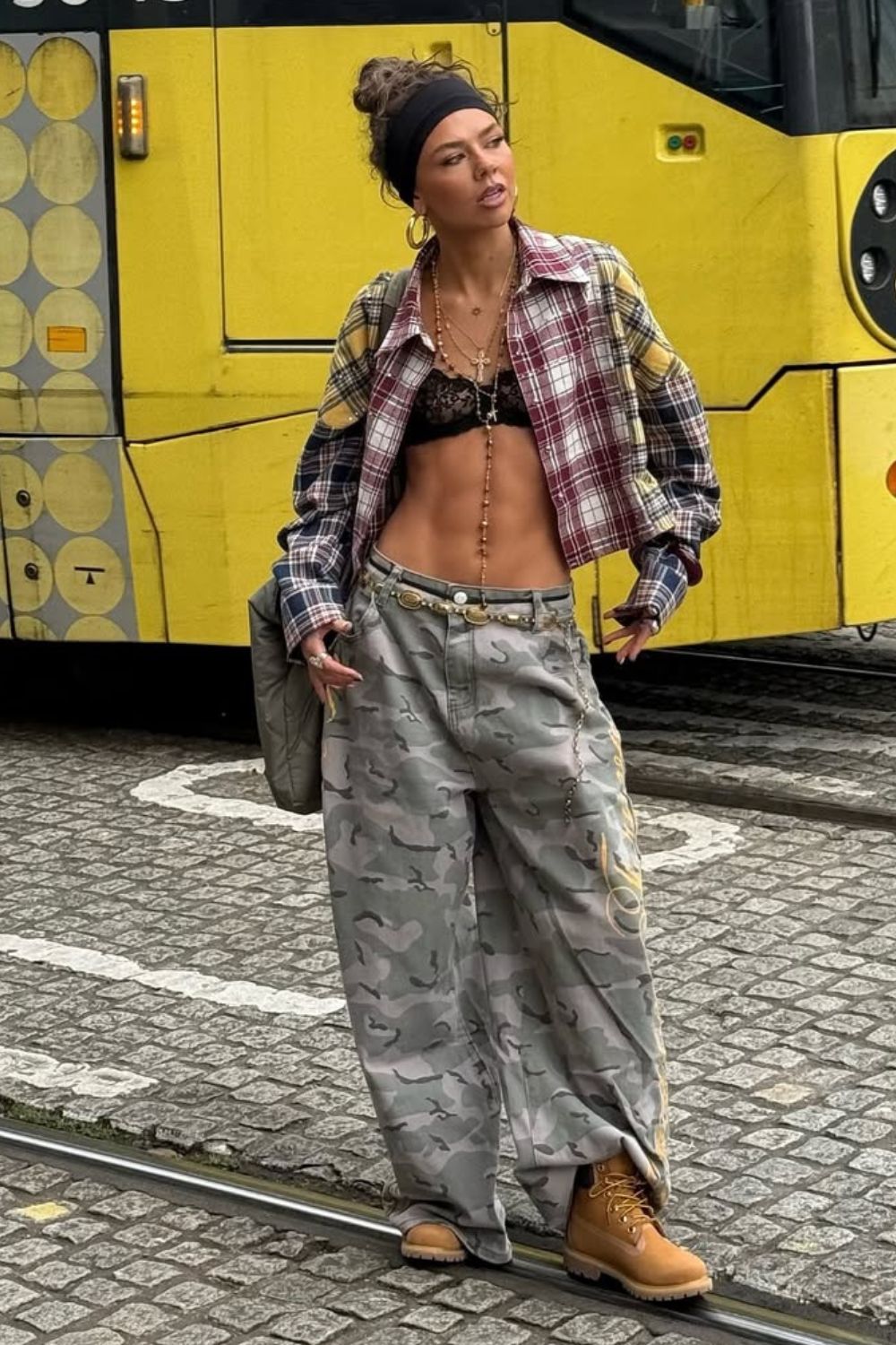 Camisa xadrez com top de renda, calça baggy com estampa camuflada e bota caramelo