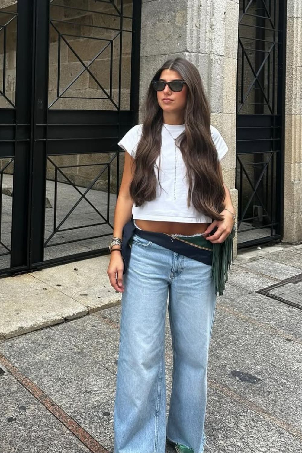 Blusa branca, calça jeans de cintura super baixa e cinto boho