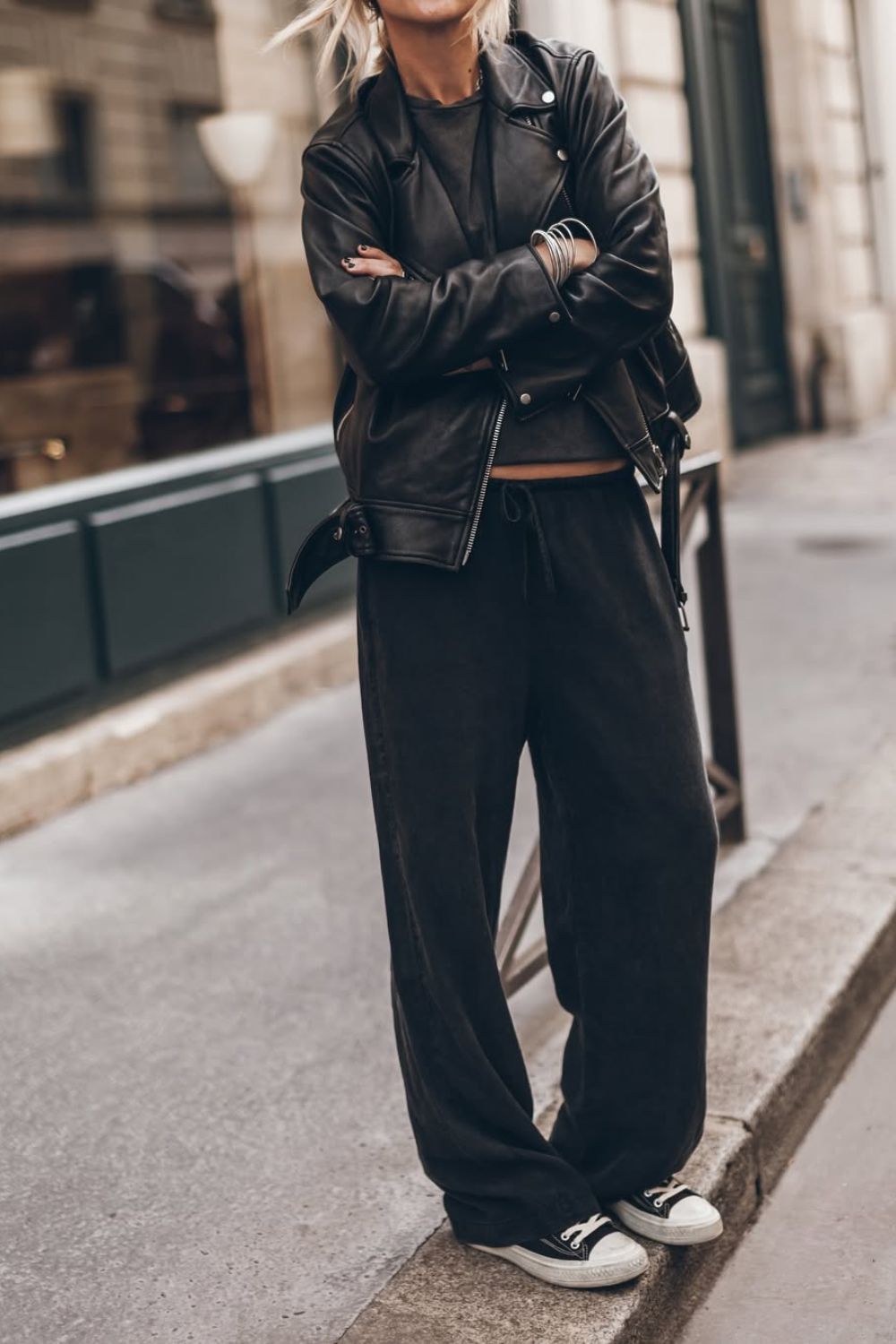 Look casual com jaqueta de couro preta, blusa preta, calça jogger e tênis all star