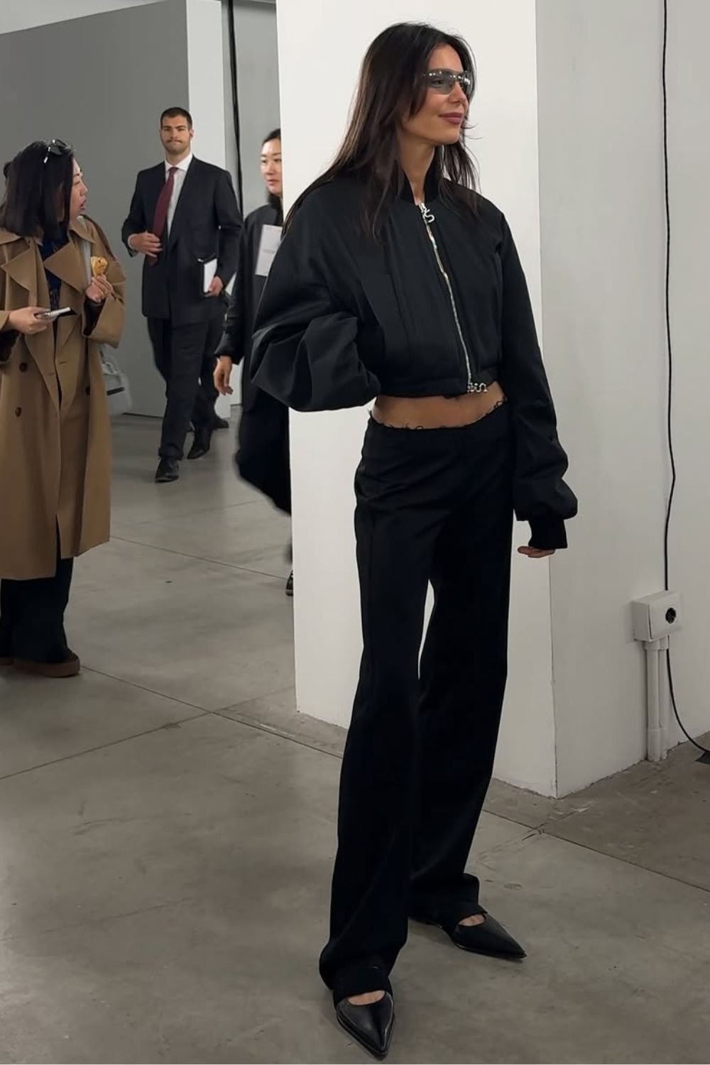 Look all black com bomber jacket, calça social de cintura super baixa e sapato de bico fino