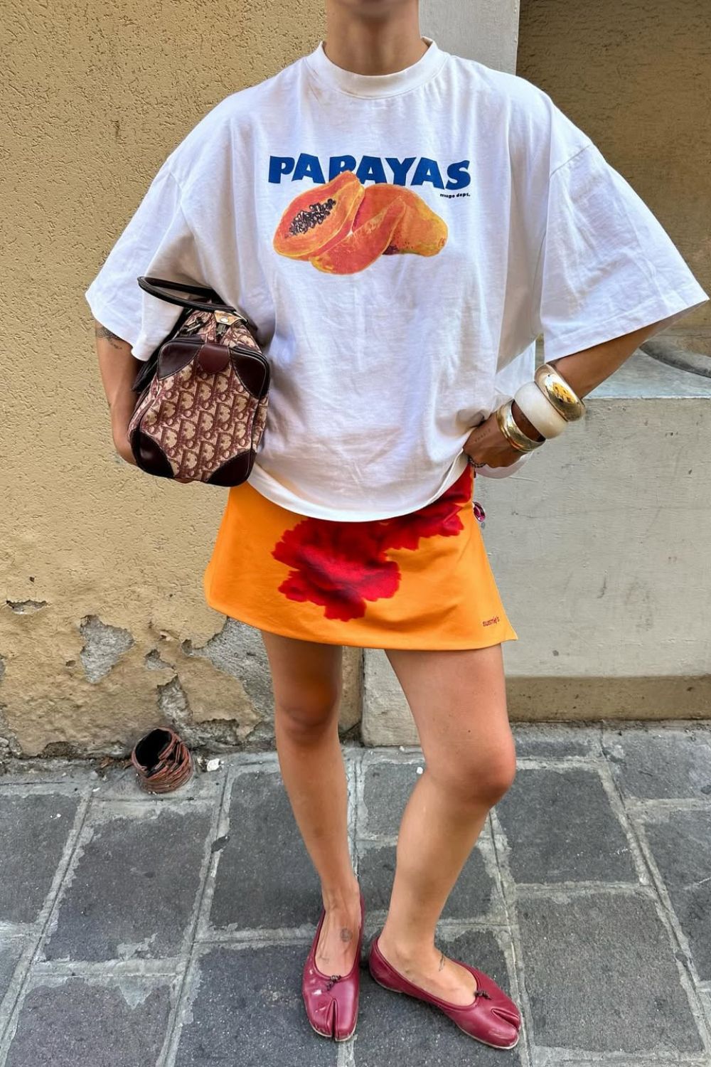 T-shirt com estampa tropical, minissaia laranja e sapatilha vermelha