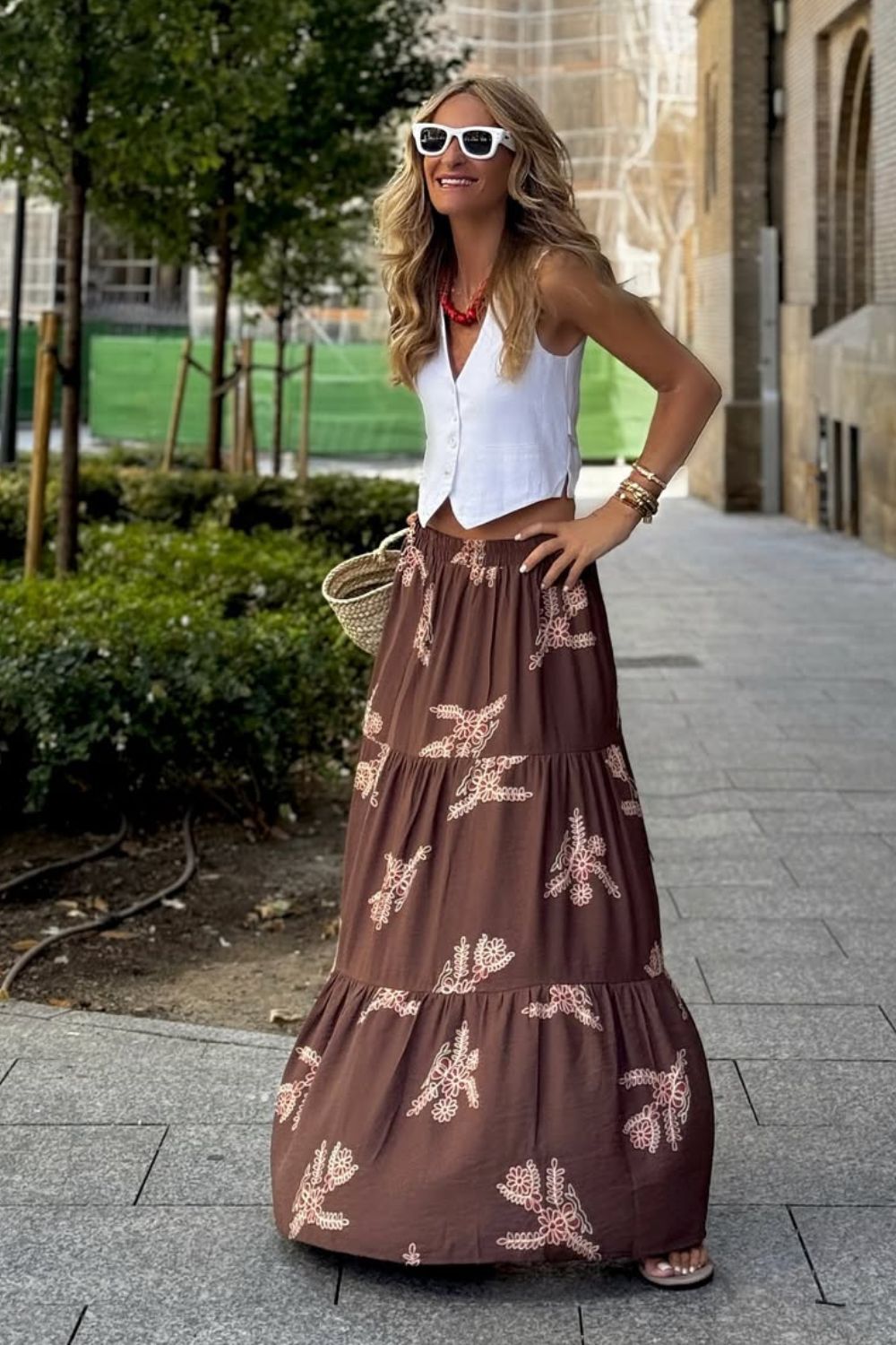 Colete branco, colar branco de bolinha e saia longa estampada floral
