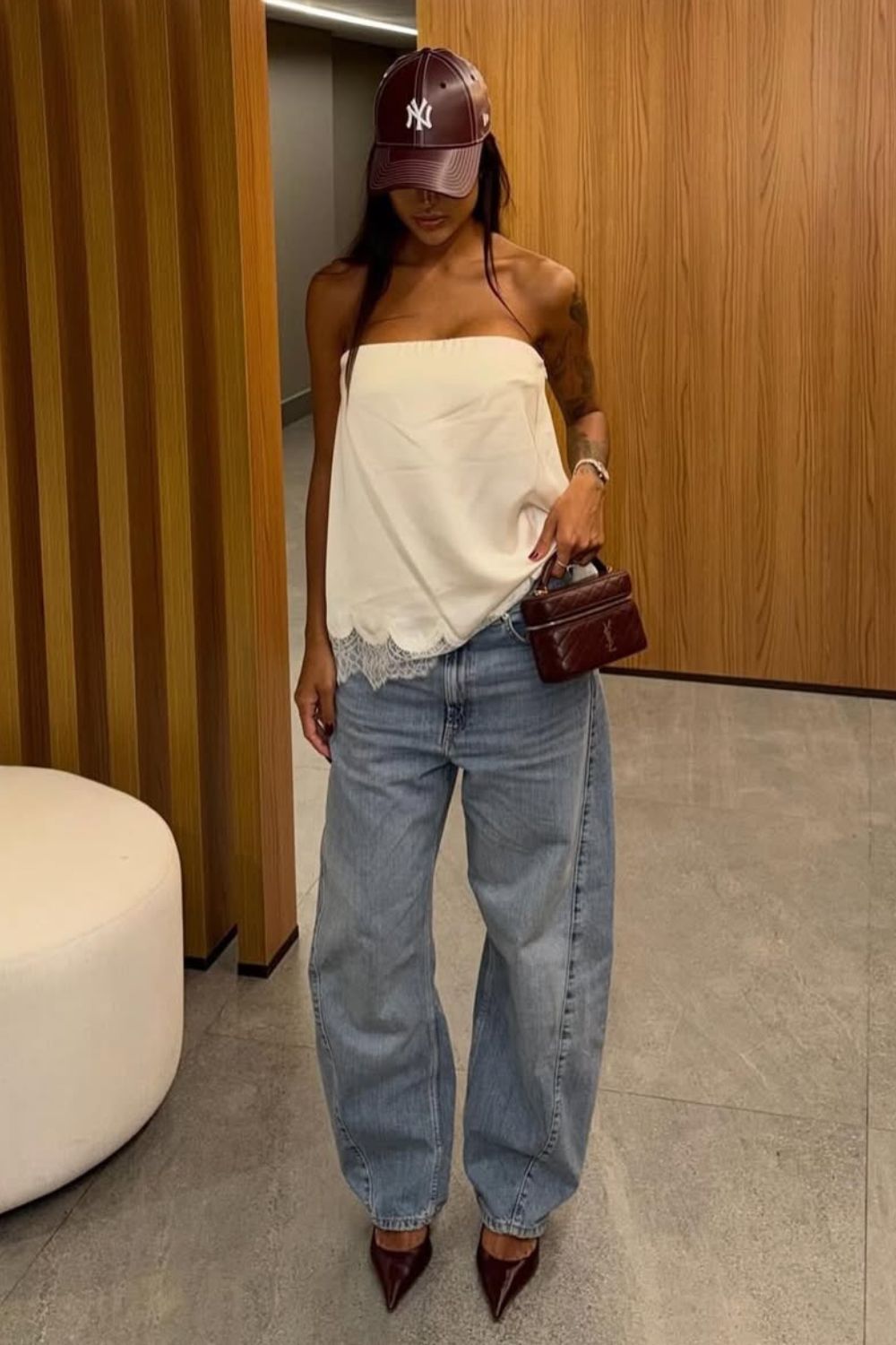 calça jeans barrel leg, e sapato de bico fino e top sem alça branco