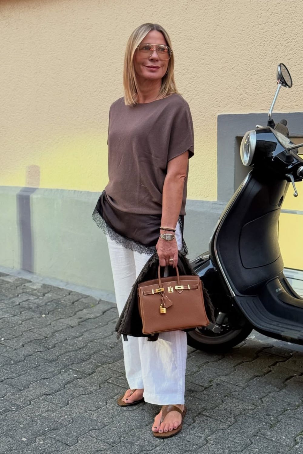 Sobreposição com top de cetim e blusa marrom, calça branca e rasteirinha