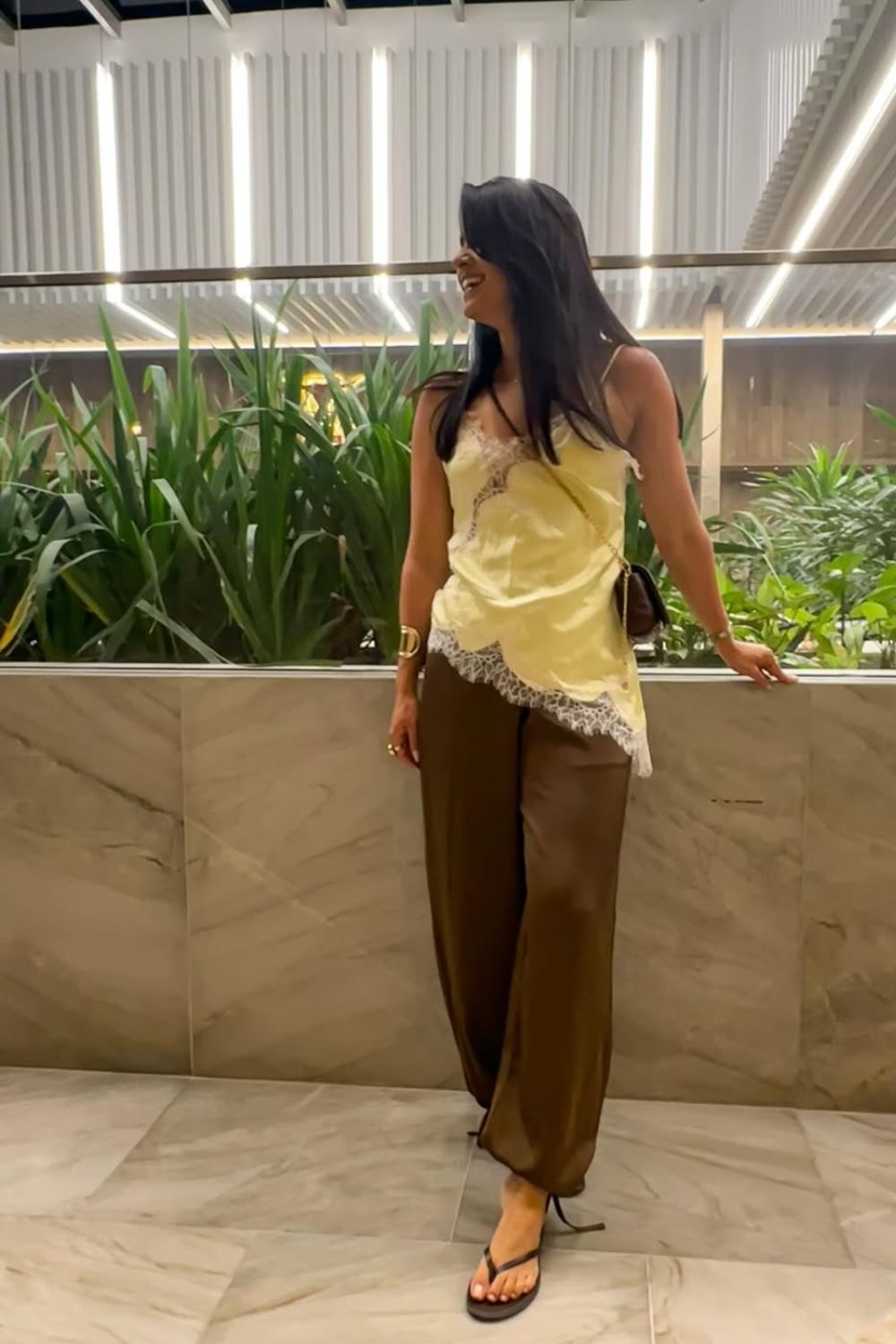 Top de seda amarelo e calça marrom