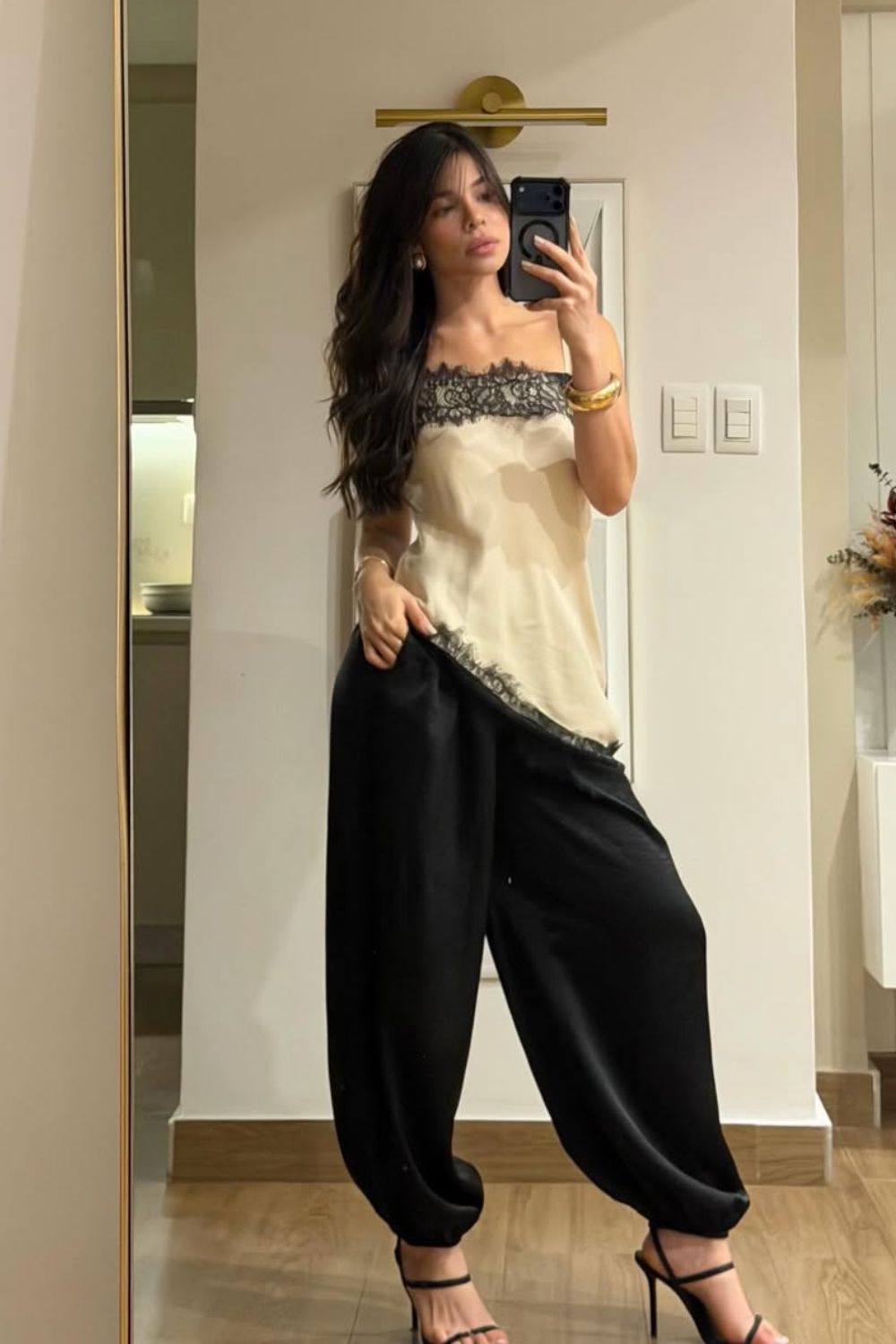 blusa seda com detalhes de renda, calça balão preta e sandália de salto fino