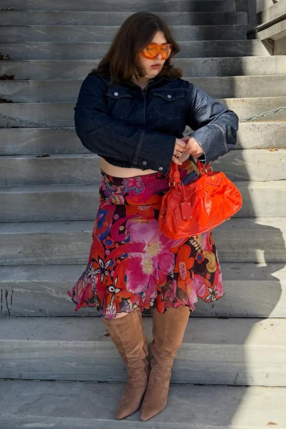 O poder das estampas, jaqueta jeans cropped, saia midi com estampa floral e bota de cano alto.