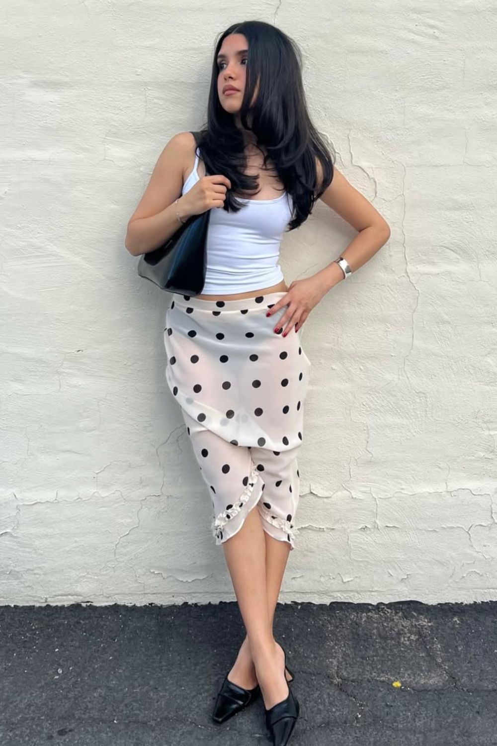 Regata branca, saia midi com estampa de poá e mule preta