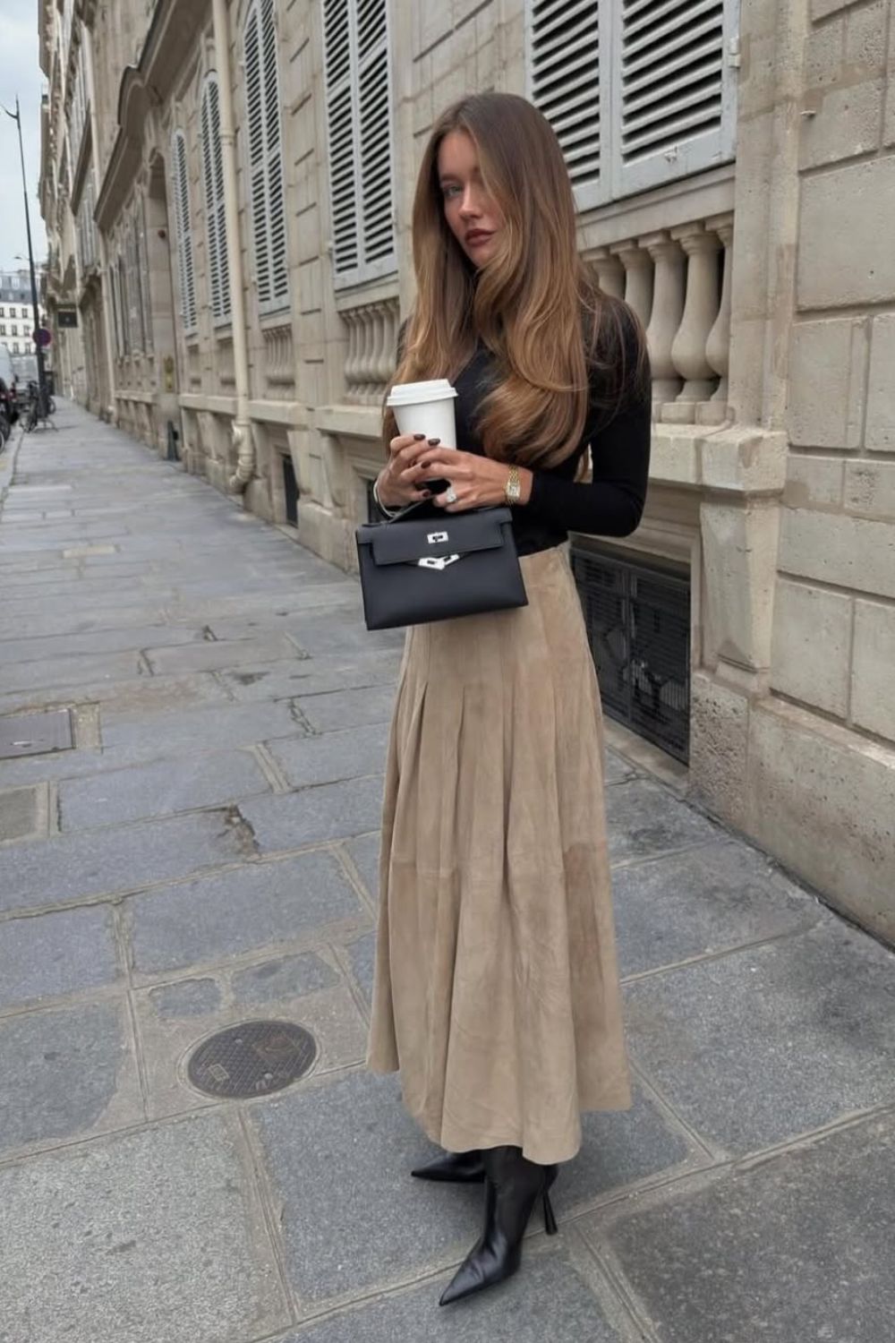 Looks para testar neste outono. blusa preta de manga longa, saia de camurça e bota de bico fino.