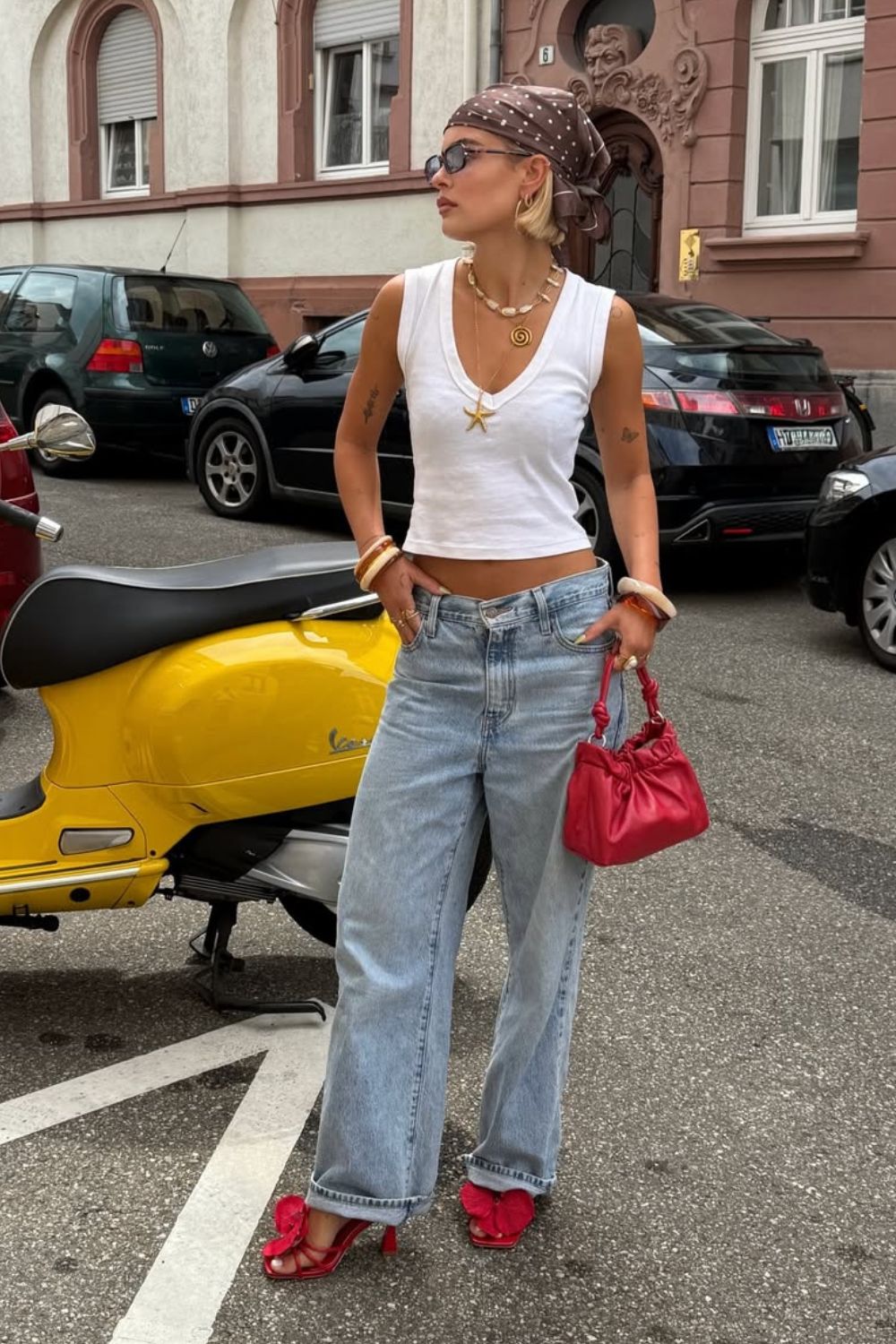 Regata branca, calça jeans de cintura baixa, mix de colares dourados de bandana marrom