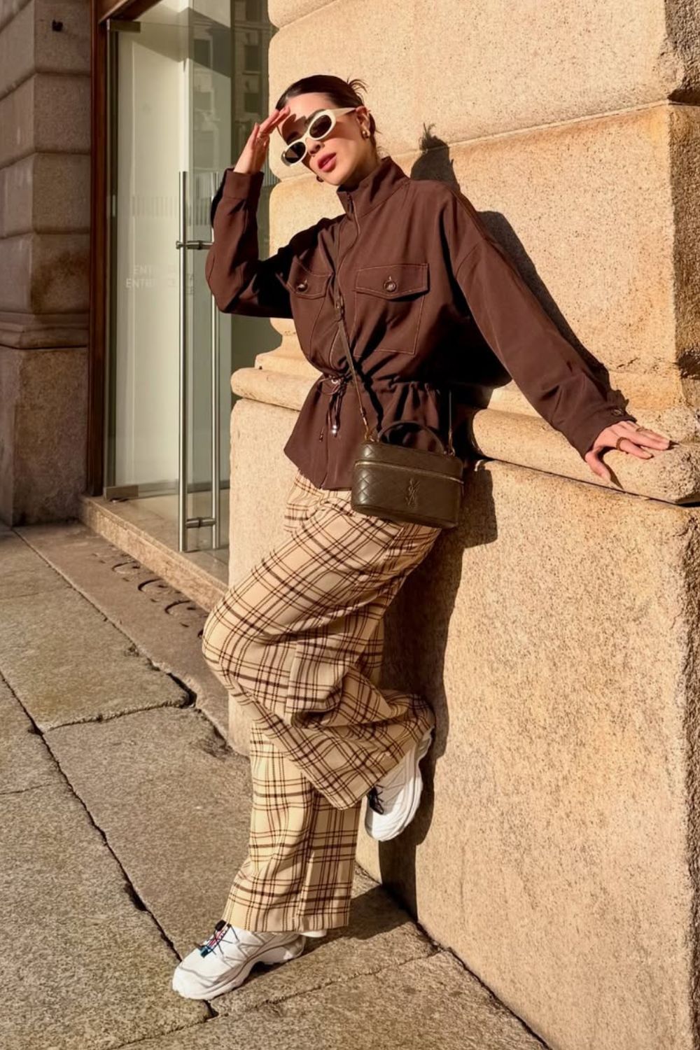 Parca marrom, calça xadrez e chunky sneakers