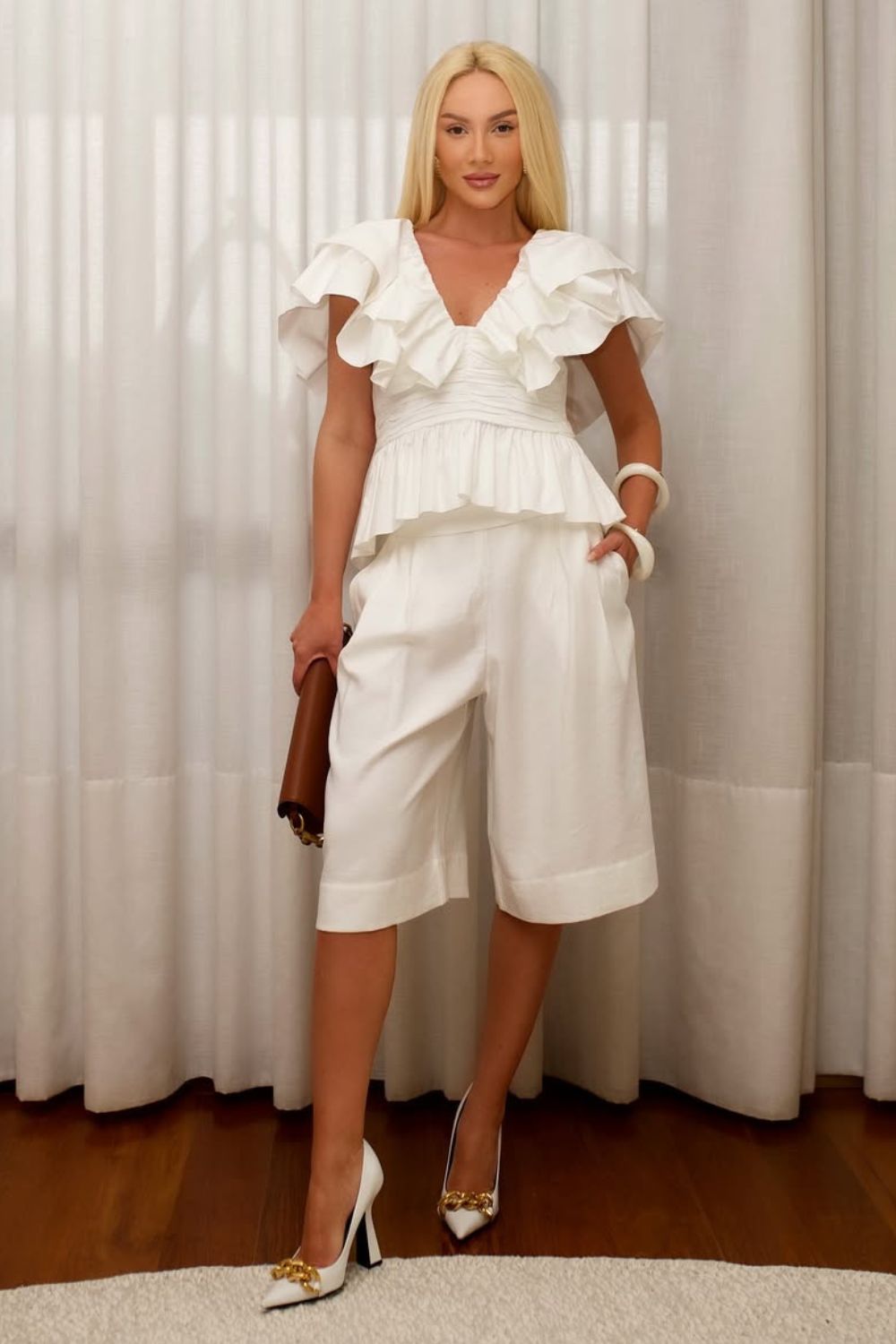 Look monocromático branco com blusa de babados, bermuda de alfaiataria e scarpin