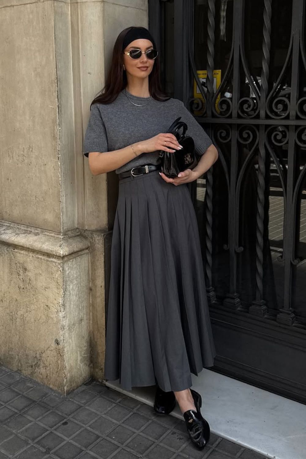 Look monocromático com blusa cinza, saia longa plissada e loafer