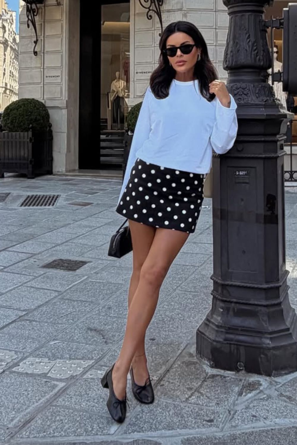 Looks românticos com blusa de manga branca e minissaia preta com estampa de bolinhas e sapatilha de vinil
