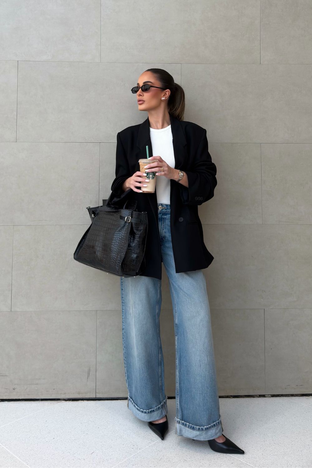 Looks para trabalhar: blusa branca, calça jeans, blazer preto e scarpin